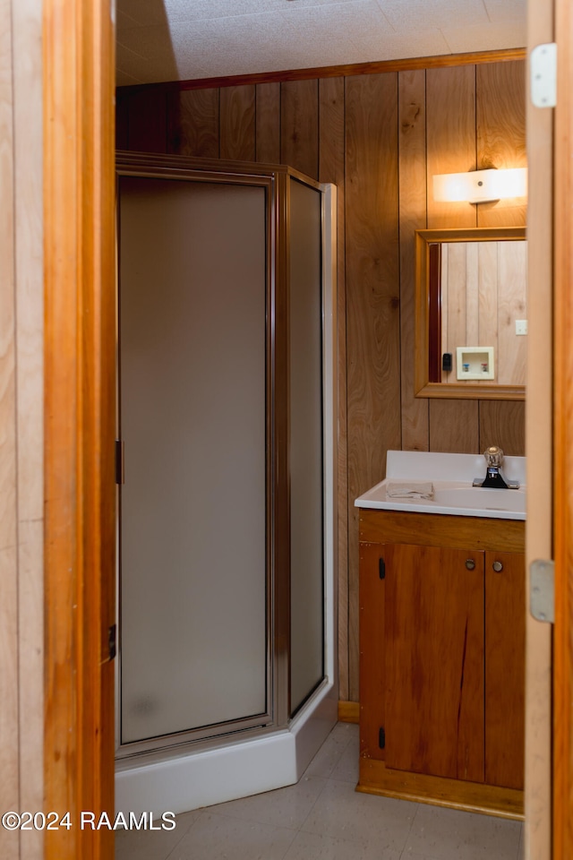 bathroom with vanity, walk in shower, and wood walls