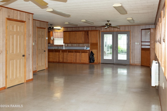 kitchen featuring wood walls, sink, radiator, and french doors