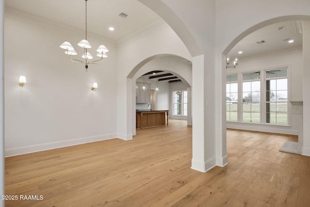 interior space featuring light hardwood / wood-style flooring, a notable chandelier, and crown molding