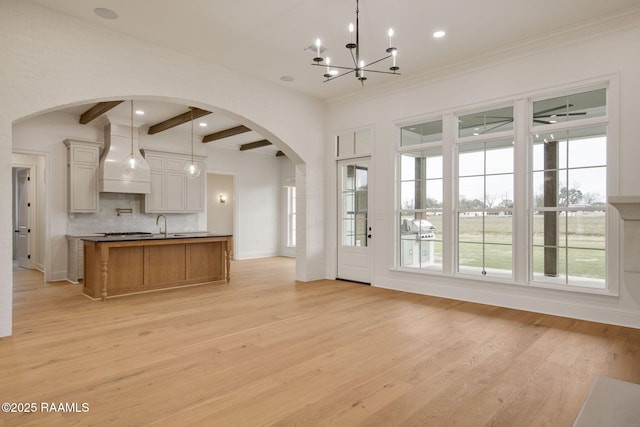 kitchen with pendant lighting, custom exhaust hood, light hardwood / wood-style flooring, beamed ceiling, and a chandelier