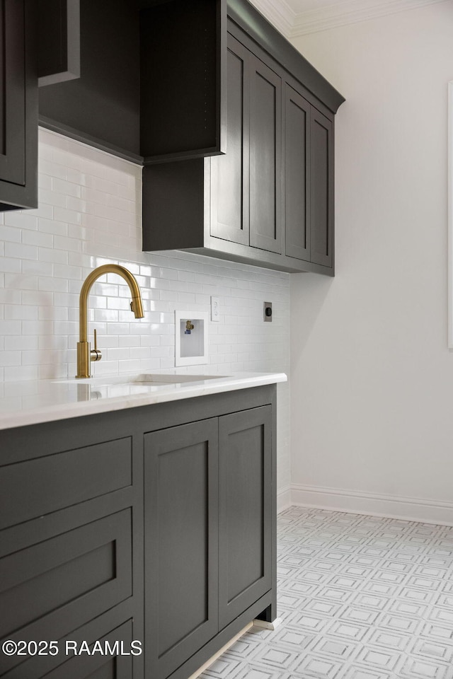 kitchen featuring ornamental molding, sink, and tasteful backsplash