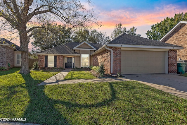 single story home featuring a yard and a garage