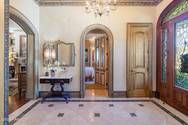 foyer entrance with a notable chandelier and ornamental molding