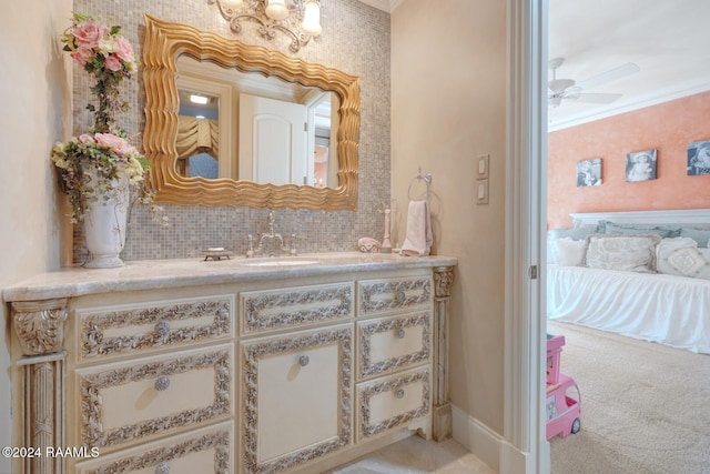 bathroom featuring vanity, ceiling fan, crown molding, and backsplash