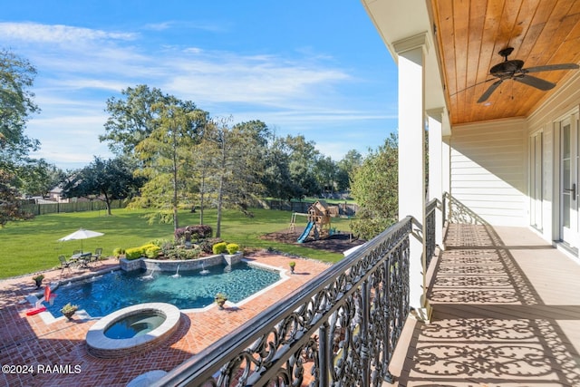 view of swimming pool with a lawn, an in ground hot tub, and pool water feature