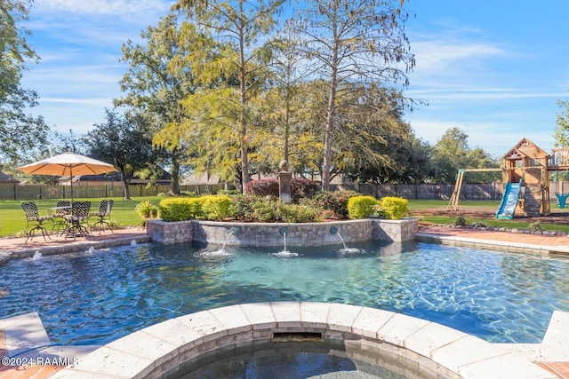 view of pool featuring a playground, a yard, an in ground hot tub, and pool water feature