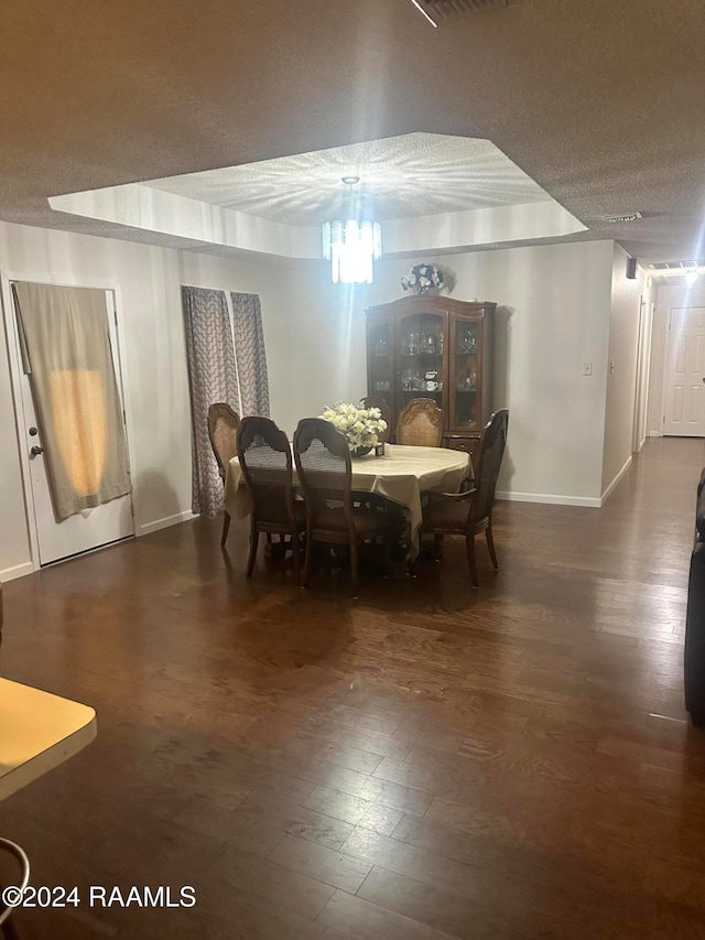 dining space with dark hardwood / wood-style flooring and a textured ceiling