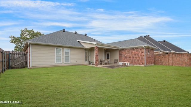 rear view of property featuring a patio area and a lawn