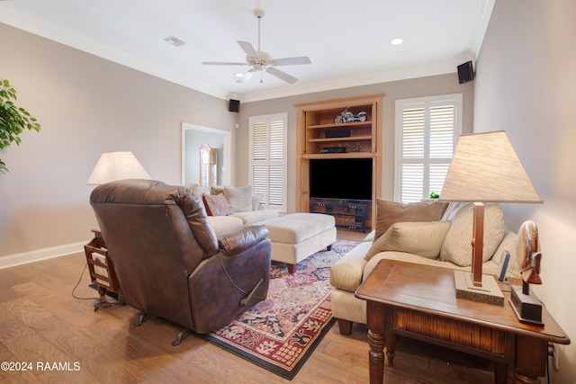 living room with ceiling fan, ornamental molding, and light wood-type flooring