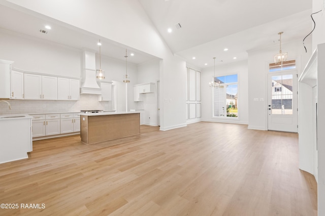 407 Sunshine Rise Dr, Broussard, LA 70518 - kitchen with high vaulted ceiling, a chandelier, backsplash, light countertops, and white cabinetry
