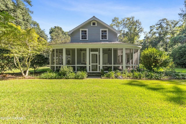 back of property with a yard and a sunroom