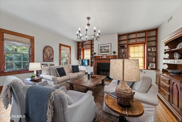 193A Notre Reve Ln, Arnaudville, LA 70512 - living area featuring light wood finished floors, a chandelier, and a fireplace
