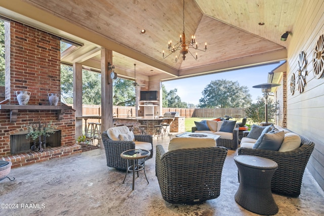 view of patio with an outdoor living space with a fireplace and exterior bar