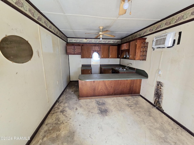 kitchen with an AC wall unit, kitchen peninsula, ceiling fan, and sink