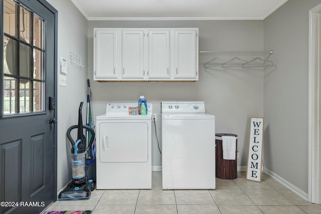 washroom with cabinets, washing machine and dryer, light tile patterned floors, and crown molding