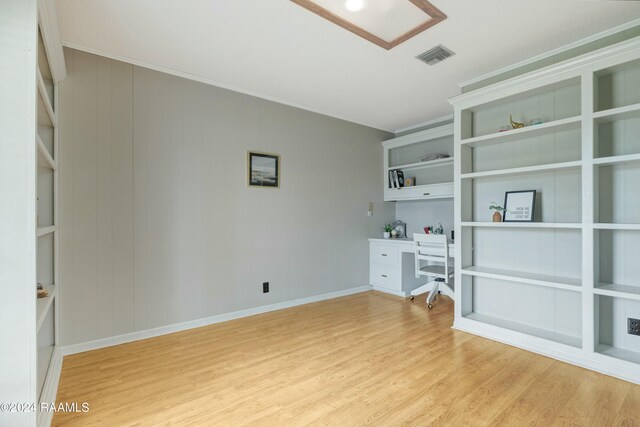 unfurnished office featuring light wood-type flooring and crown molding