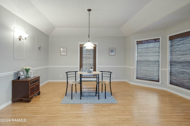 dining area featuring a textured ceiling and light hardwood / wood-style flooring