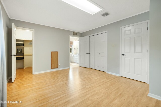 unfurnished bedroom featuring light hardwood / wood-style floors and ornamental molding