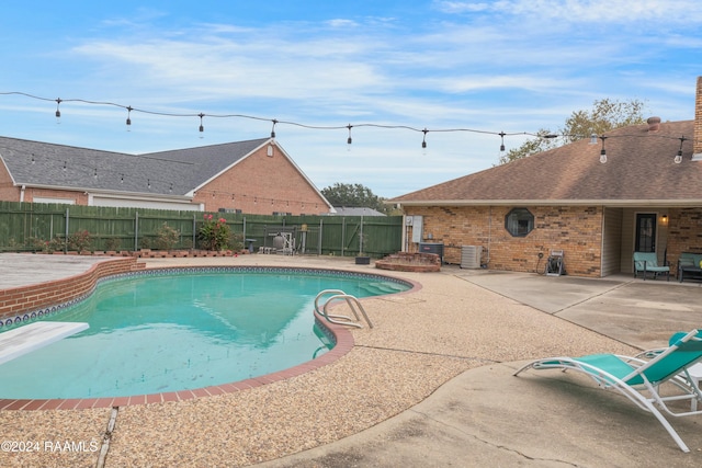 view of swimming pool with central AC unit and a patio