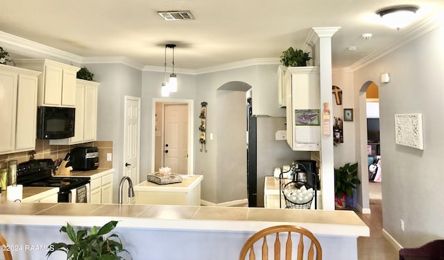 kitchen with black appliances, kitchen peninsula, and crown molding