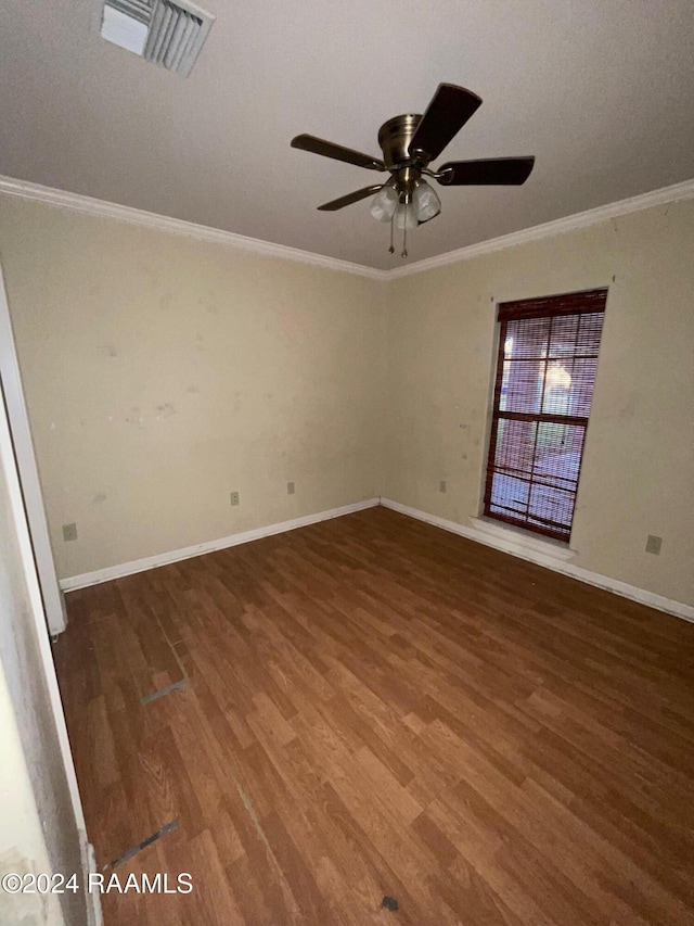 empty room featuring ceiling fan, dark wood-type flooring, a textured ceiling, and ornamental molding