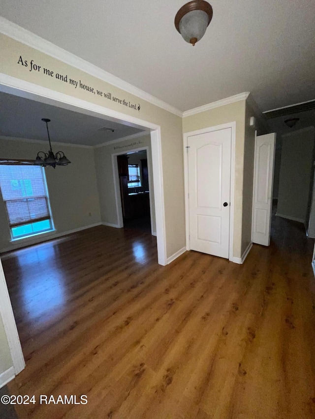 unfurnished dining area with ornamental molding, dark wood-type flooring, and an inviting chandelier