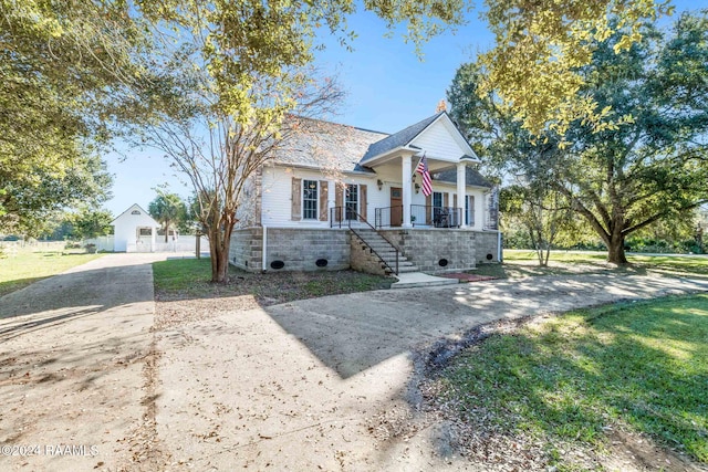 view of front of house featuring covered porch and a front yard