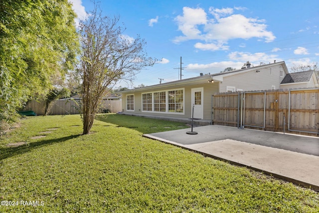 back of house featuring a yard and a patio