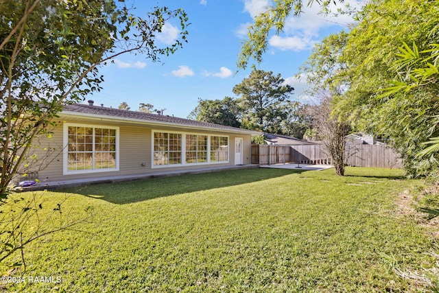 back of house featuring a yard and a patio area