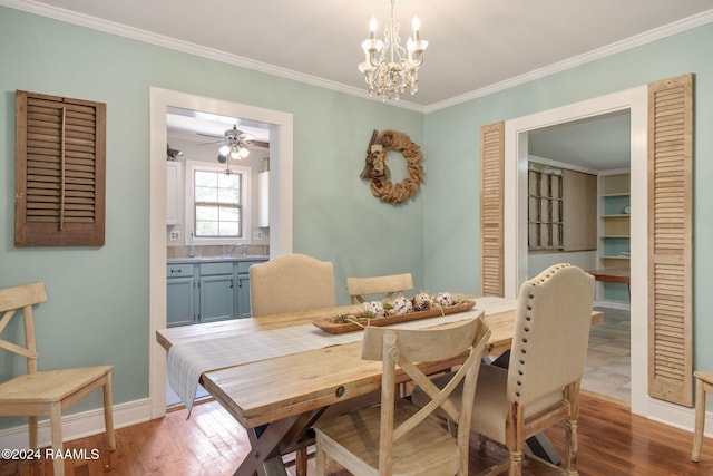 dining room with sink, ornamental molding, ceiling fan with notable chandelier, and hardwood / wood-style flooring