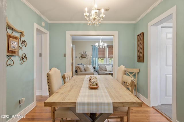 dining area with crown molding, a chandelier, and light hardwood / wood-style floors