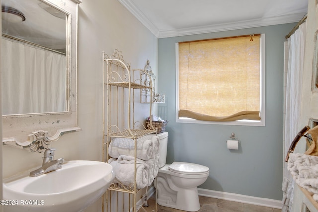 bathroom featuring tile patterned floors, crown molding, sink, and toilet