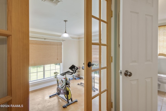 workout area featuring crown molding