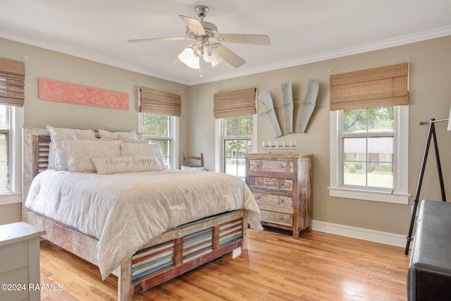 bedroom with multiple windows, ceiling fan, crown molding, and light wood-type flooring