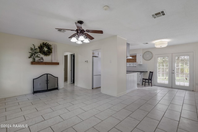 unfurnished living room with ceiling fan, french doors, and light tile patterned floors