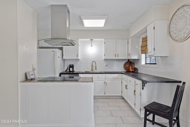 kitchen featuring decorative backsplash, extractor fan, sink, white fridge, and white cabinetry