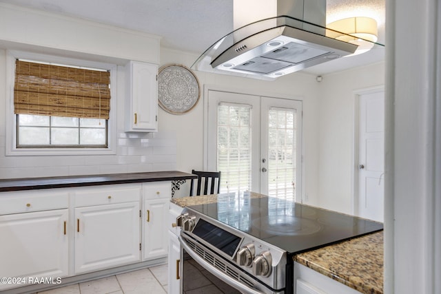 kitchen featuring french doors, backsplash, island range hood, white cabinets, and range