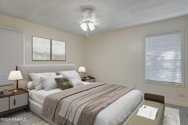 tiled bedroom featuring a textured ceiling and ceiling fan