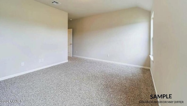 carpeted spare room featuring lofted ceiling