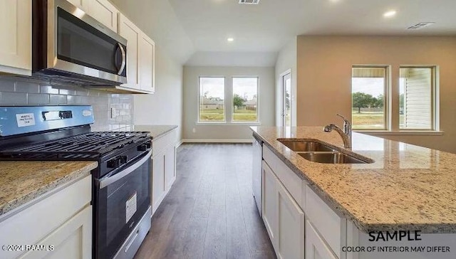 kitchen featuring white cabinetry, a kitchen island with sink, sink, and appliances with stainless steel finishes