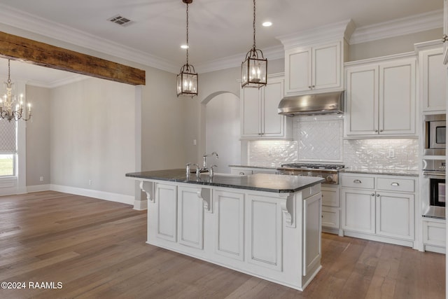 kitchen featuring decorative light fixtures, light wood-type flooring, an island with sink, and stainless steel appliances