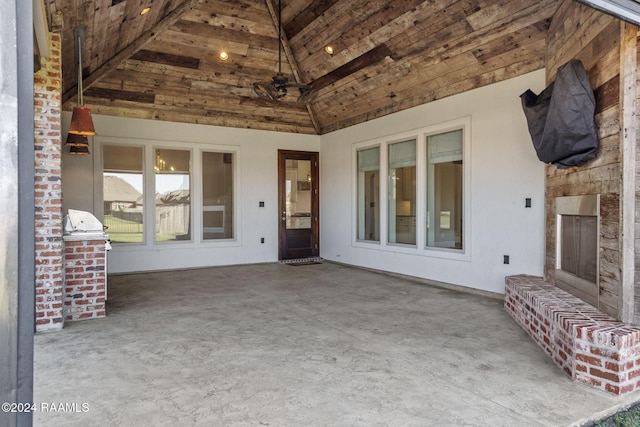 view of patio with an outdoor brick fireplace, area for grilling, and ceiling fan