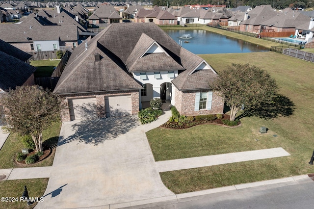 view of front of house with a water view, a front yard, and a garage