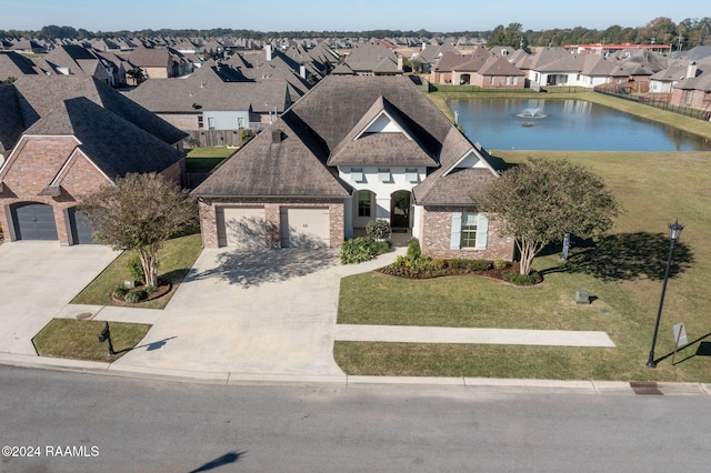 view of front of property featuring a front lawn, a water view, and a garage