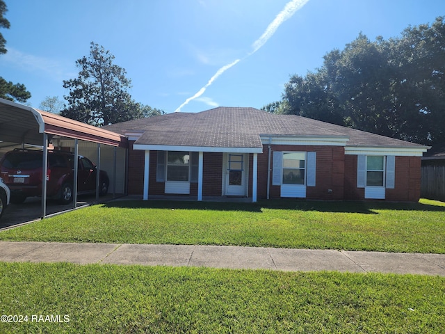 ranch-style house featuring a carport, covered porch, and a front yard