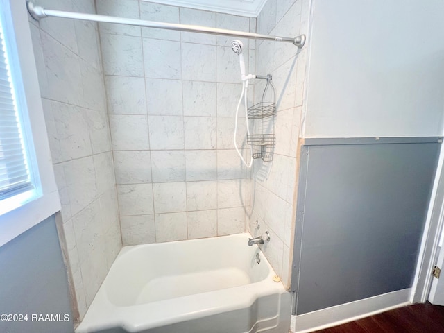 bathroom featuring wood-type flooring and tiled shower / bath