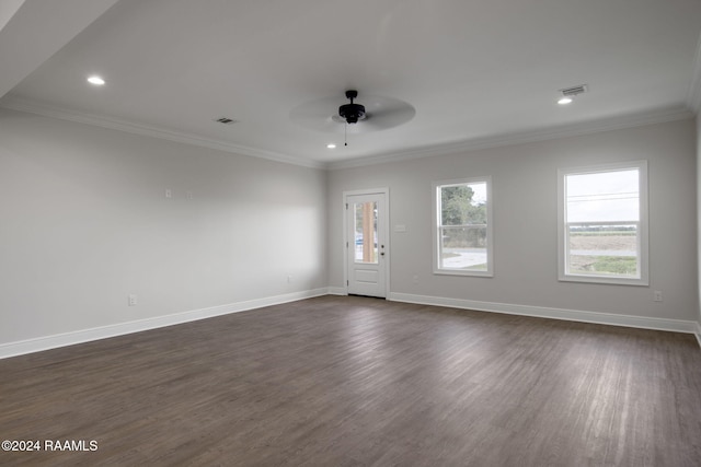 empty room featuring visible vents, baseboards, dark wood finished floors, and crown molding