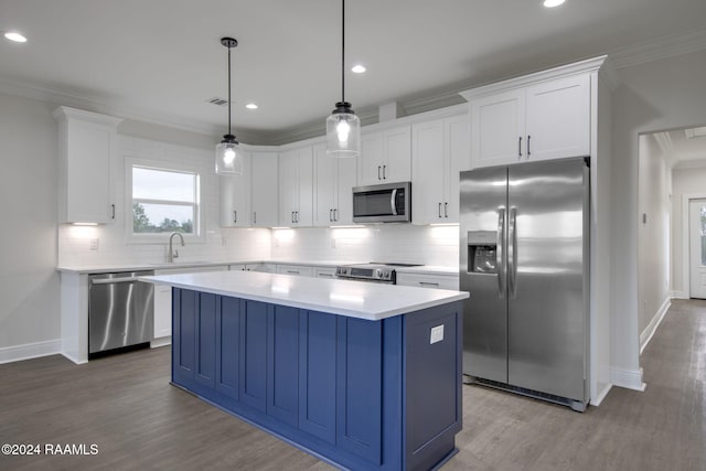 kitchen with a kitchen island, white cabinets, light countertops, appliances with stainless steel finishes, and hanging light fixtures