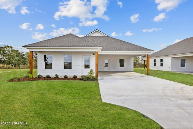 view of front of home featuring a shingled roof, concrete driveway, and a front yard