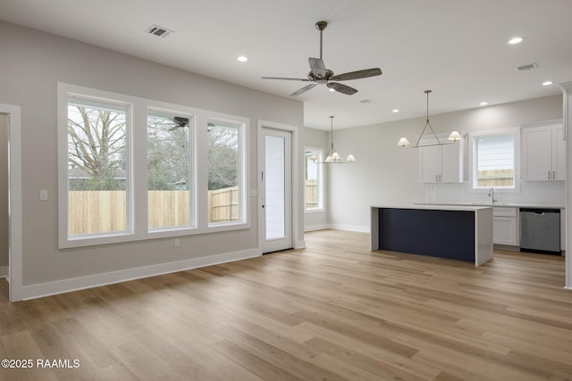 kitchen featuring plenty of natural light, dishwasher, a center island, and white cabinets